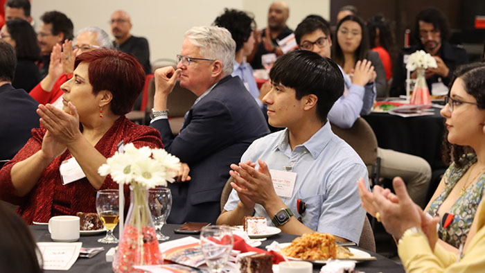 Audience members applaud at a Graduation and Recognition Reception